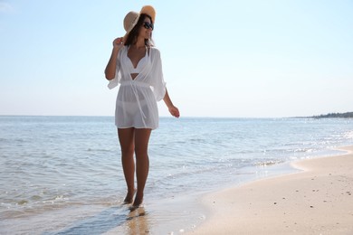 Photo of Young woman with beautiful body on sandy beach. Space for text