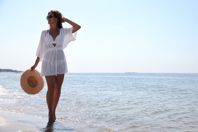 Photo of Young woman with beautiful body on beach. Space for text