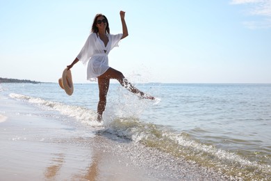 Photo of Young woman with beautiful body on sandy beach. Space for text