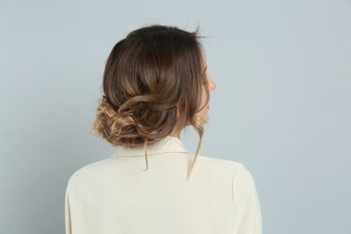 Photo of Young woman with beautiful hairstyle on light grey background