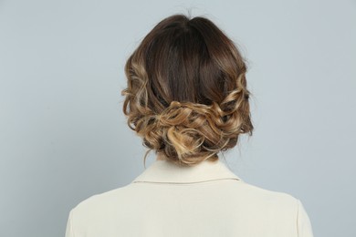 Photo of Young woman with beautiful hairstyle on light grey background