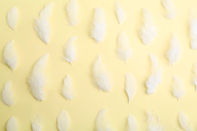 Photo of Beautiful fluffy feathers on beige background, flat lay