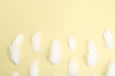 Photo of Beautiful fluffy feathers on beige background, flat lay