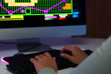 Photo of Woman using computer keyboard at white table indoors, closeup