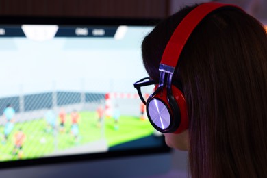 Photo of Woman in headphones watching game live stream indoors, closeup