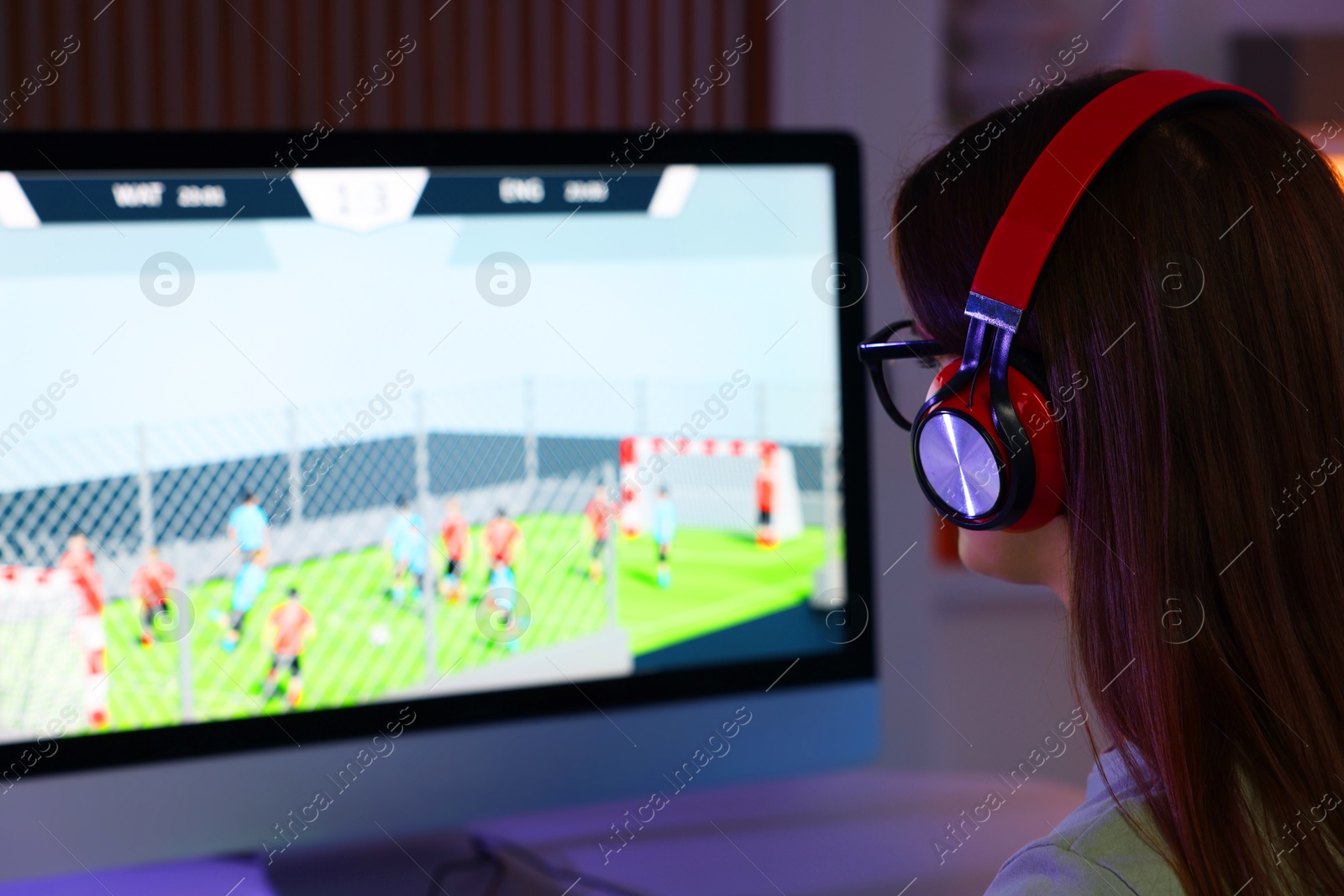 Photo of Woman in headphones watching game live stream indoors