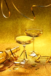 Photo of Champagne, confetti and streamers on golden background