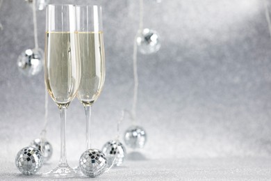 Photo of Champagne in glasses and decor on silver background. Space for text