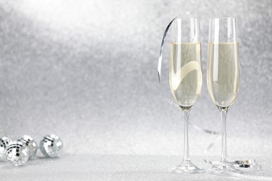 Photo of Champagne in glasses and decor on silver background. Space for text