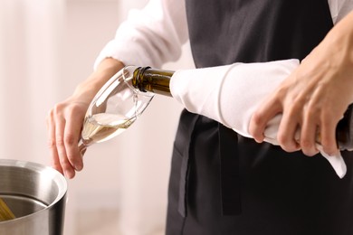 Photo of Waiter pouring champagne into glass indoors, closeup