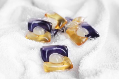 Photo of Laundry detergent capsules on white towel, closeup