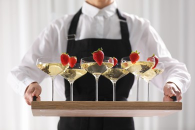 Photo of Waiter holding tray with glasses of champagne indoors, closeup