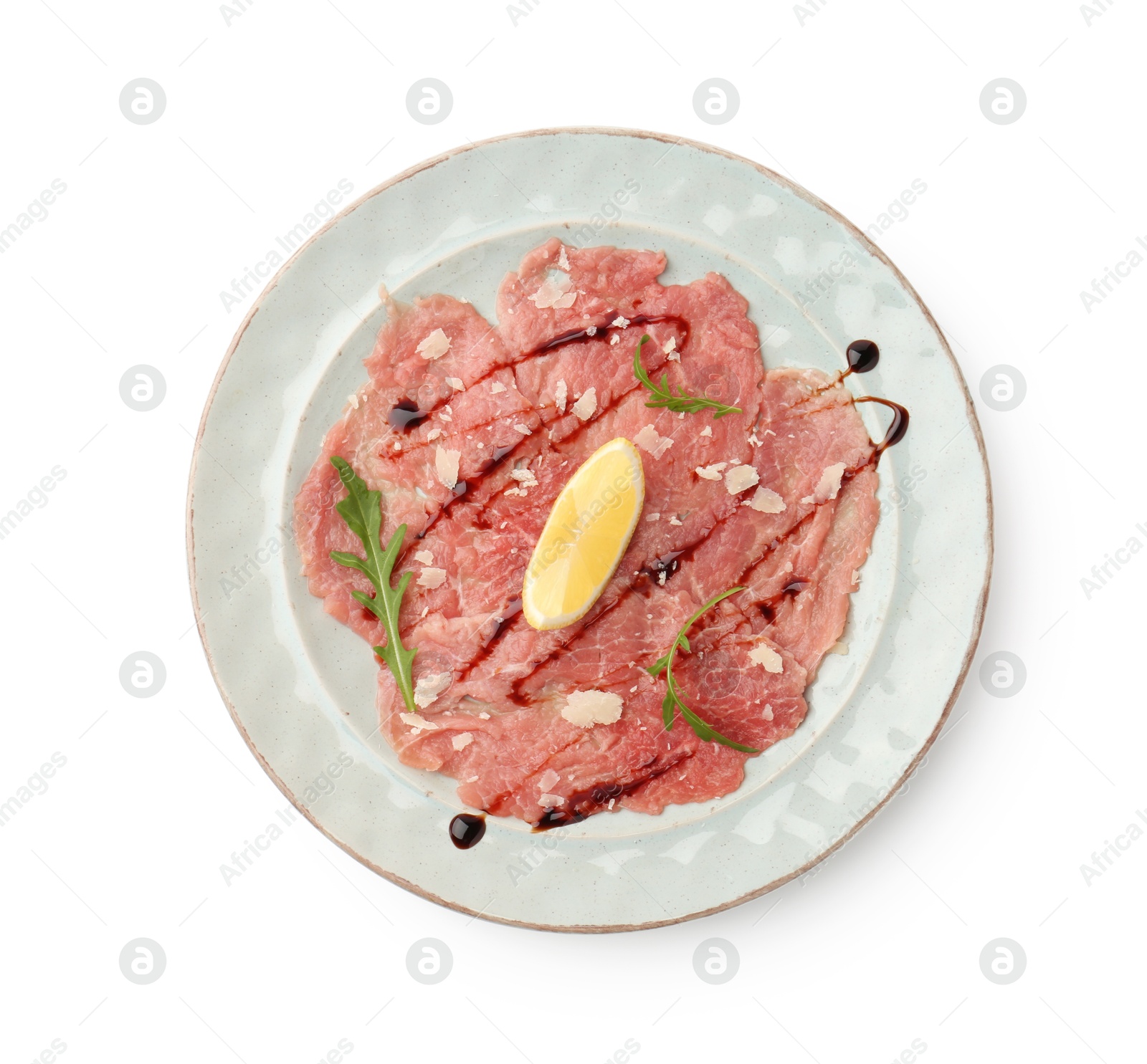 Photo of Delicious beef carpaccio with arugula, cheese, balsamic vinegar and lemon isolated on white, top view