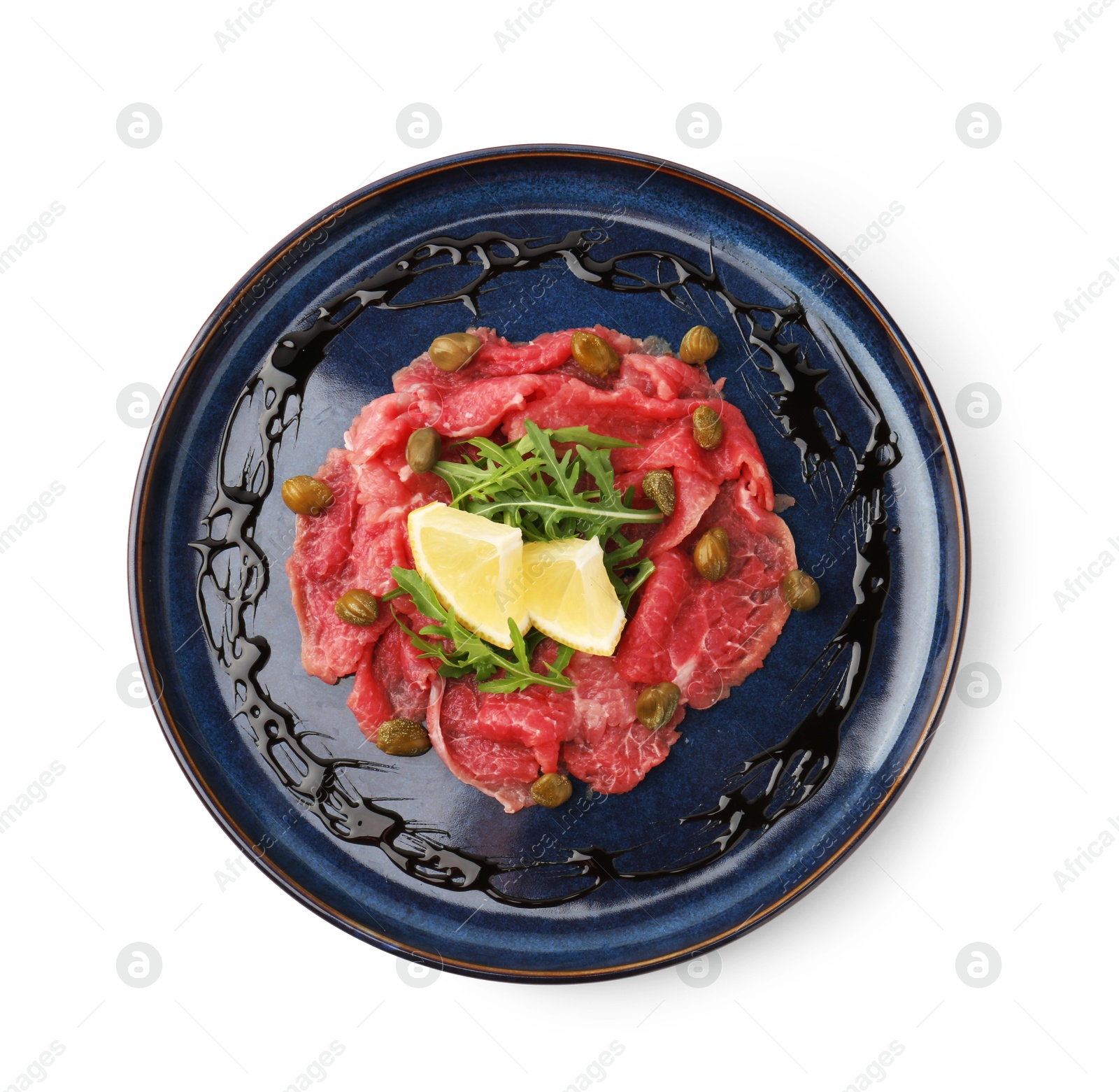 Photo of Fresh beef carpaccio with arugula, lemon and capers isolated on white, top view