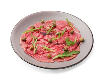 Photo of Fresh beef carpaccio with arugula, capers and sauce isolated on white