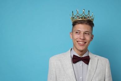 Photo of Handsome man wearing luxury crown on light blue background, space for text