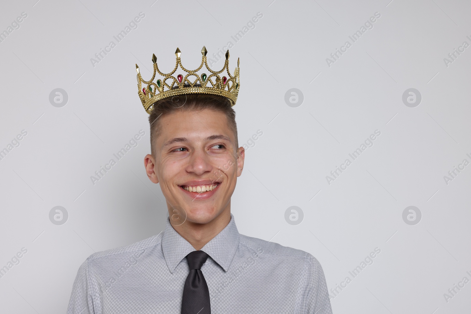 Photo of Handsome man wearing luxury crown on white background, space for text