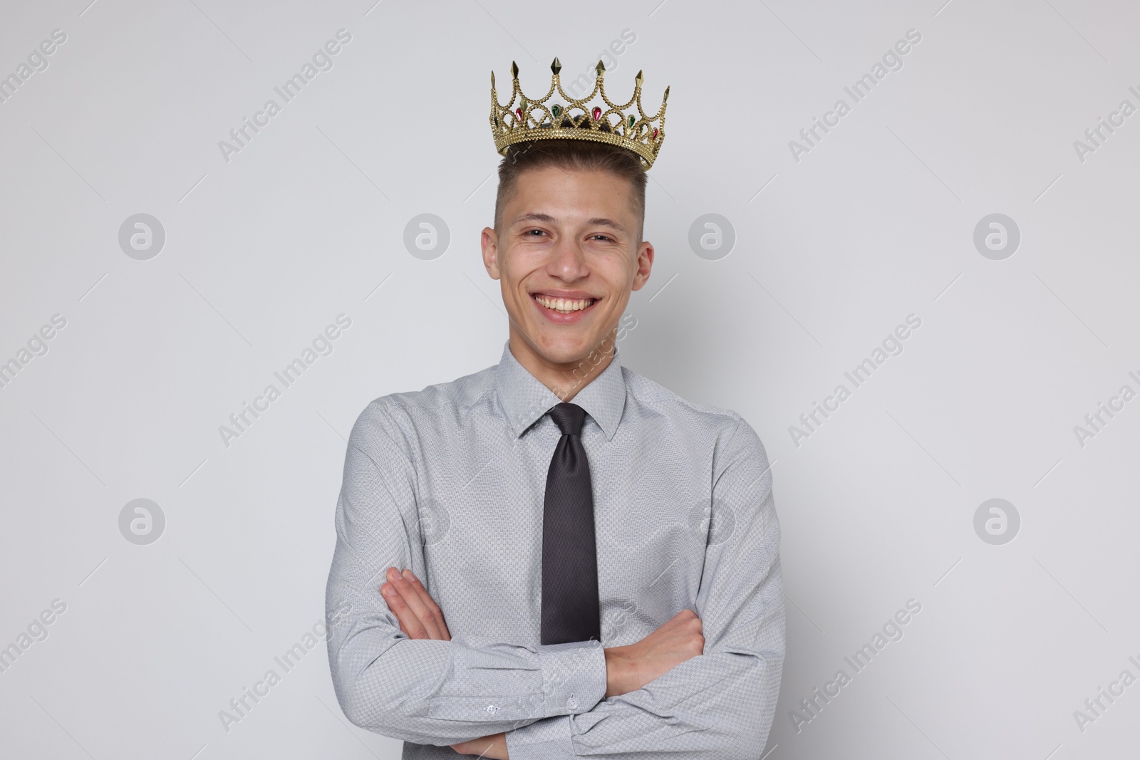 Photo of Handsome man wearing luxury crown on white background