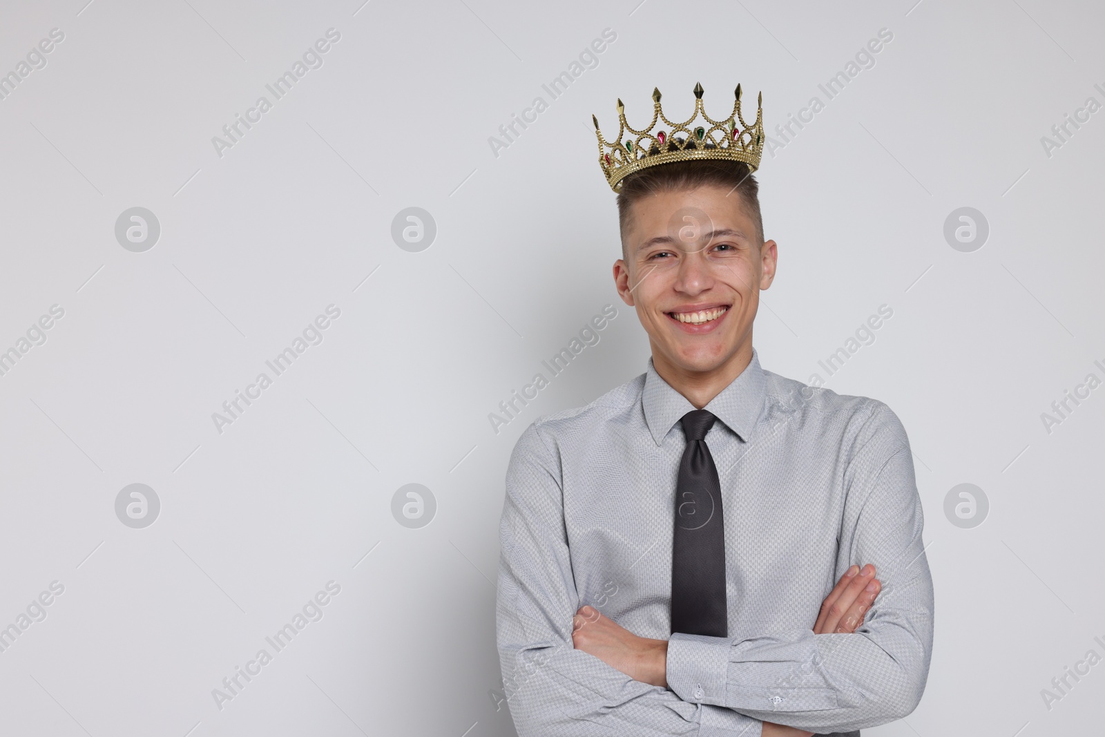 Photo of Handsome man wearing luxury crown on white background, space for text