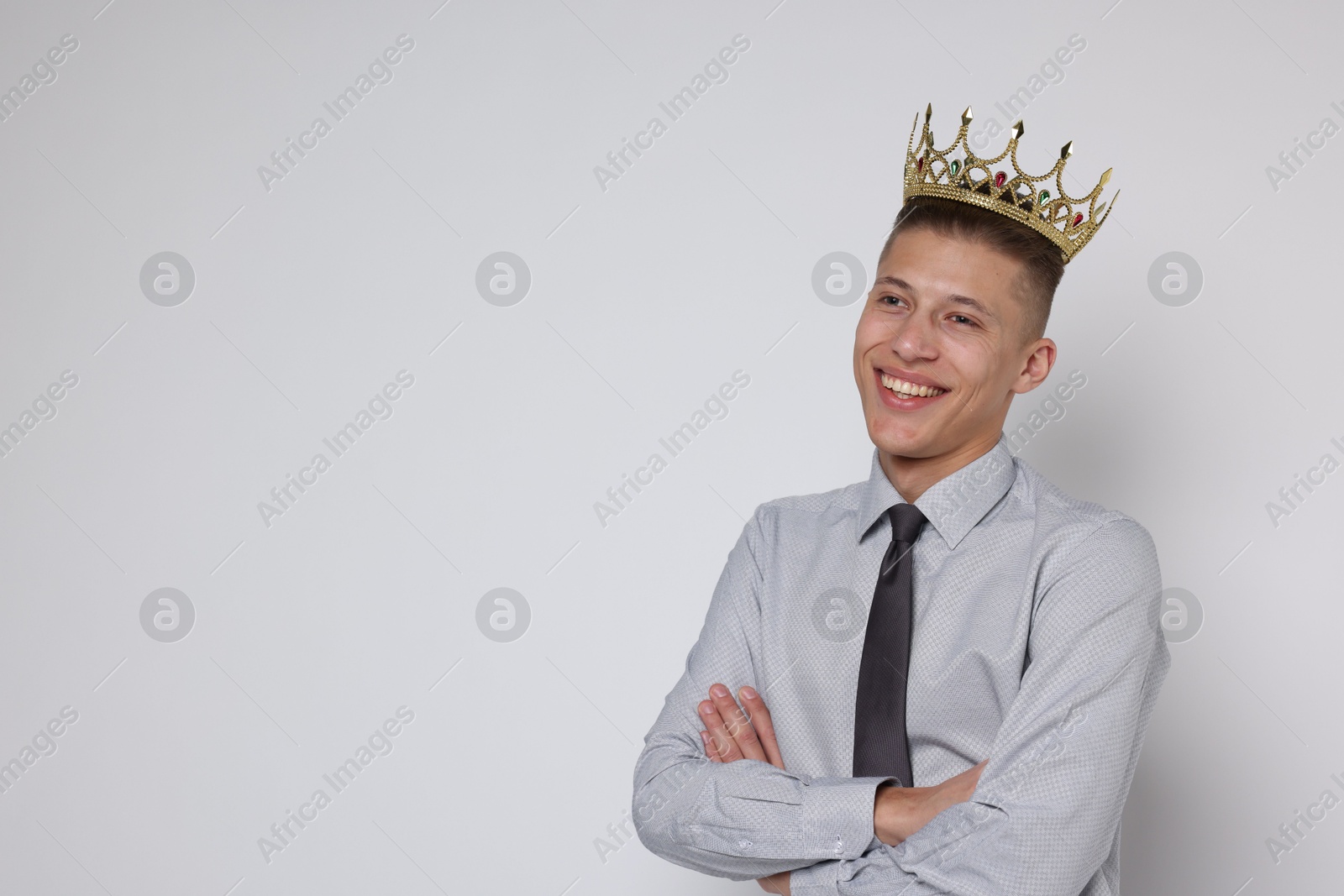 Photo of Handsome man wearing luxury crown on white background, space for text