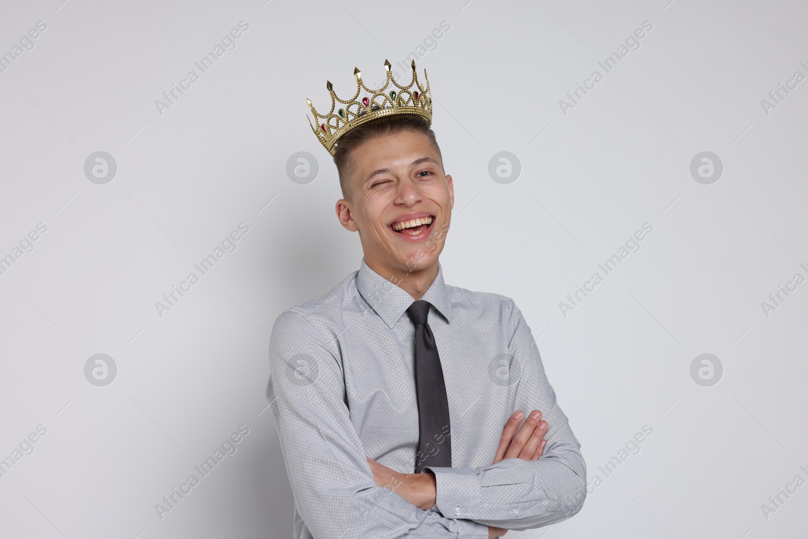 Photo of Handsome man wearing luxury crown on white background