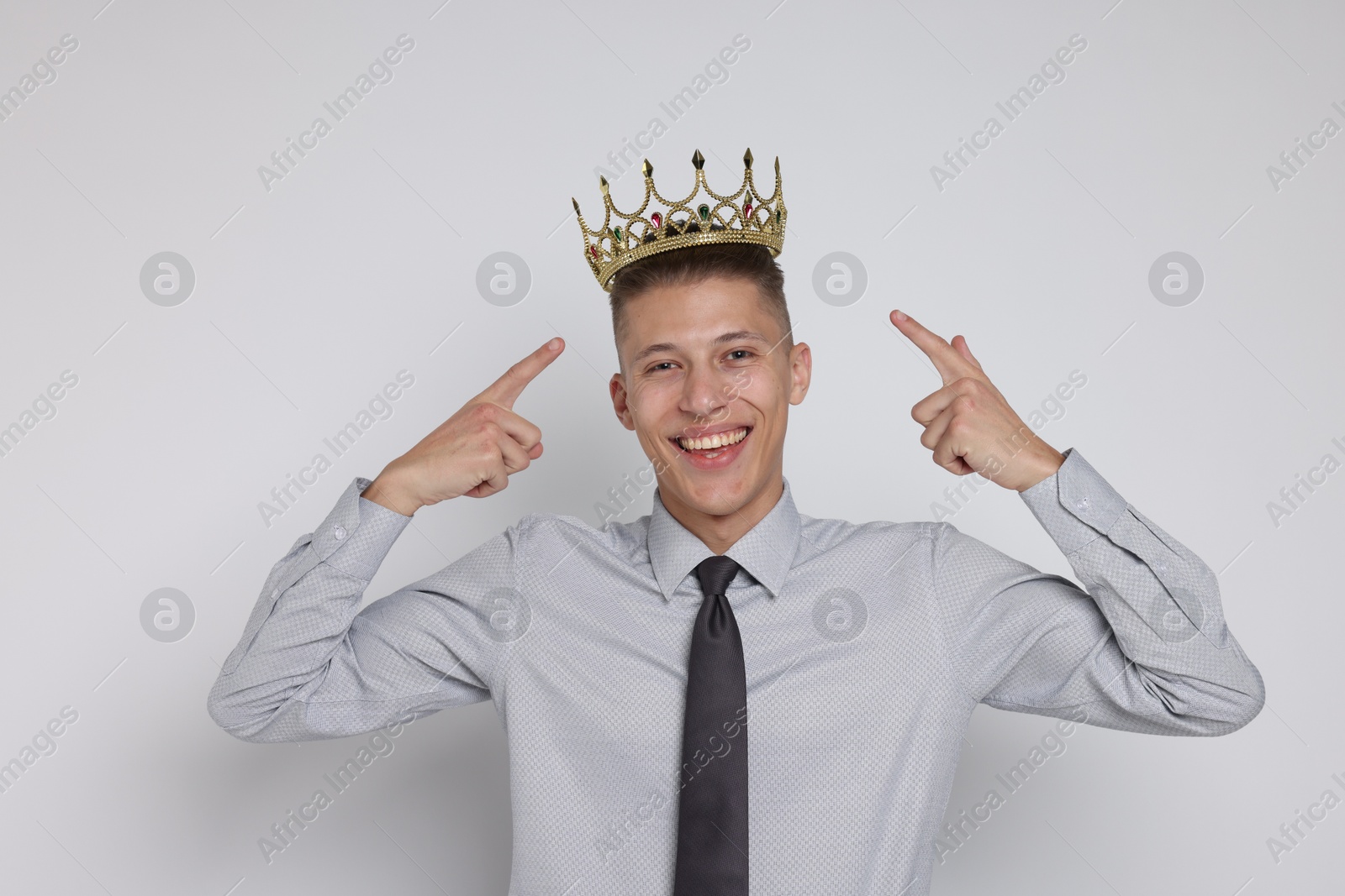 Photo of Handsome man wearing luxury crown on white background