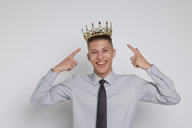 Photo of Handsome man wearing luxury crown on white background