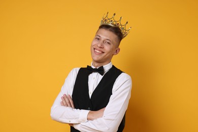 Photo of Handsome man wearing luxury crown on orange background