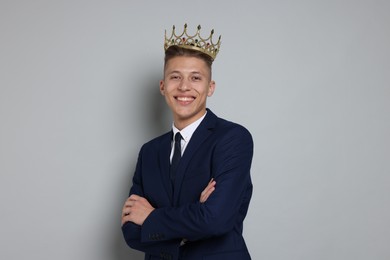 Photo of Handsome man wearing luxury crown on gray background