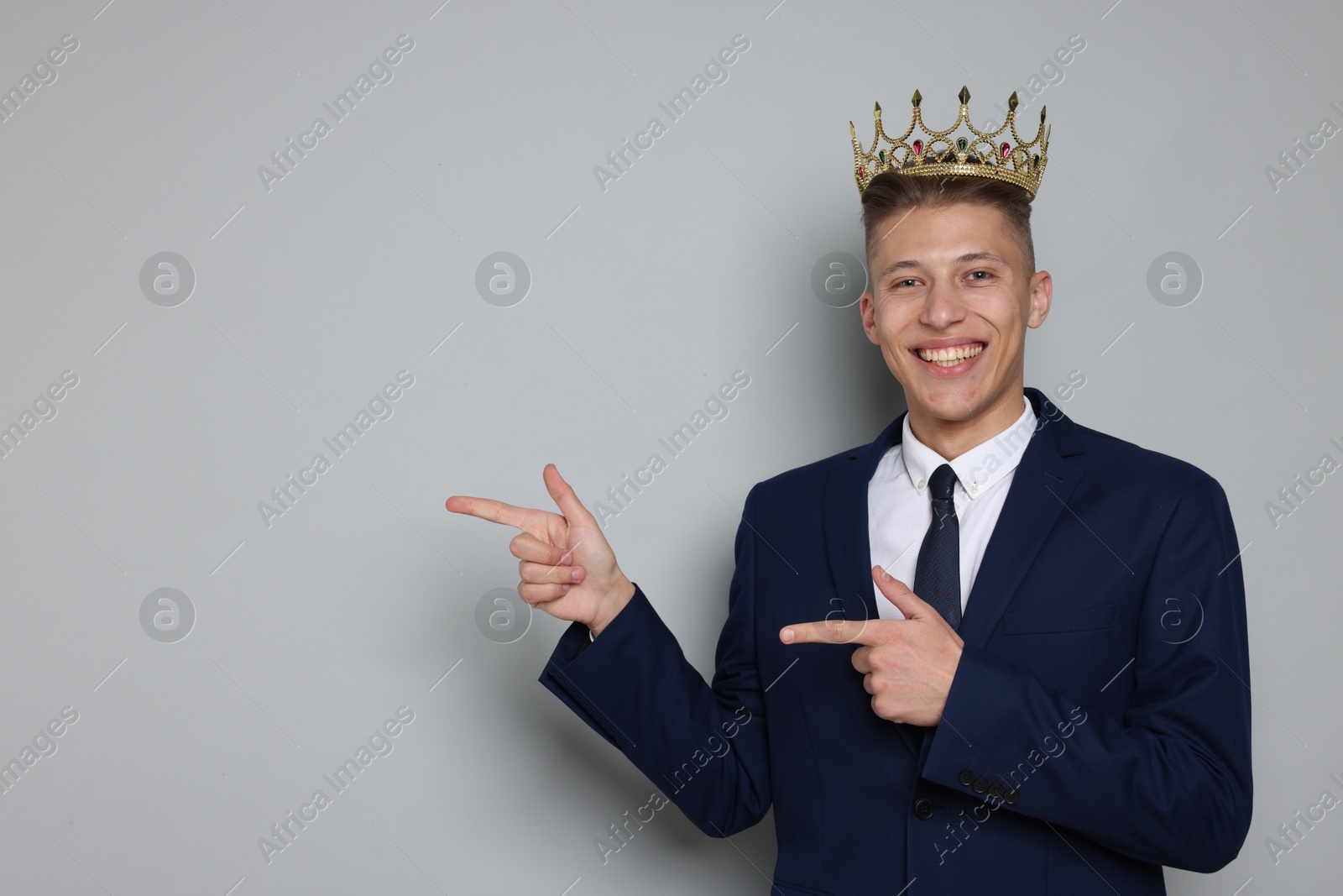 Photo of Handsome man wearing luxury crown on gray background, space for text