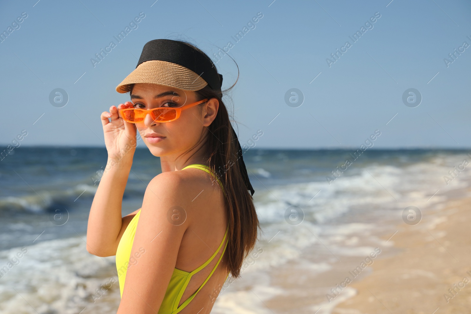 Photo of Beautiful young woman with bright sunglasses on beach