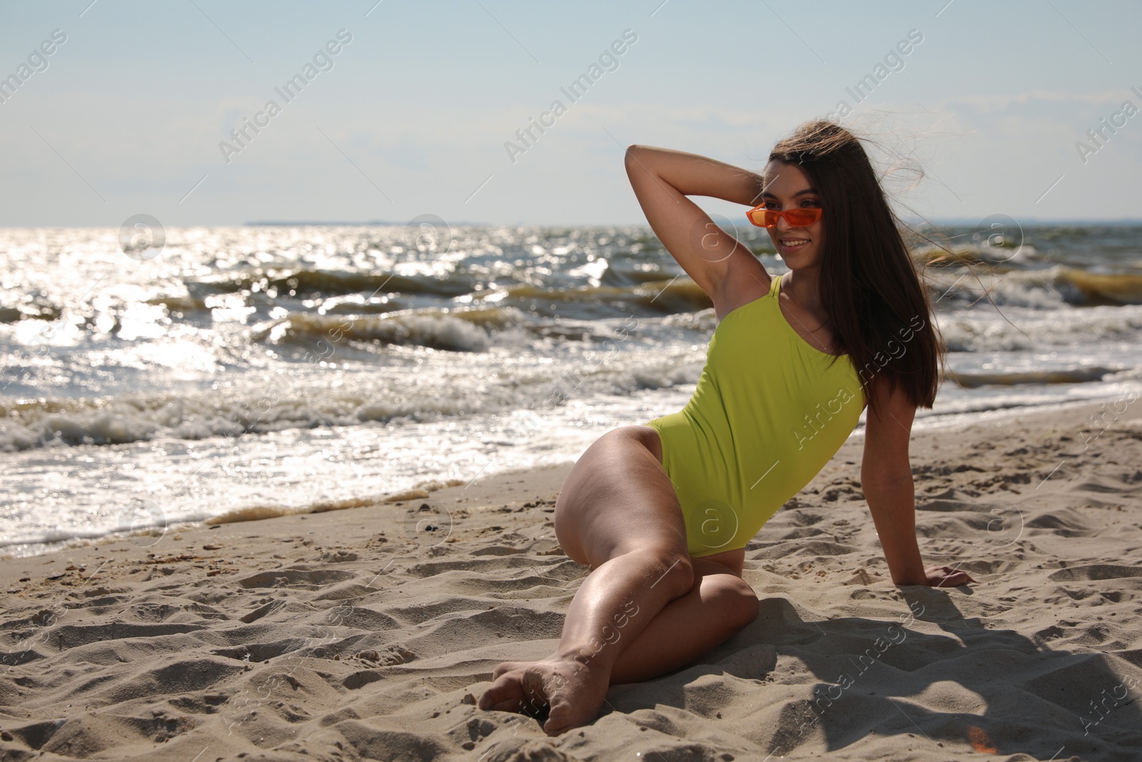 Photo of Beautiful young woman with attractive body posing on beach