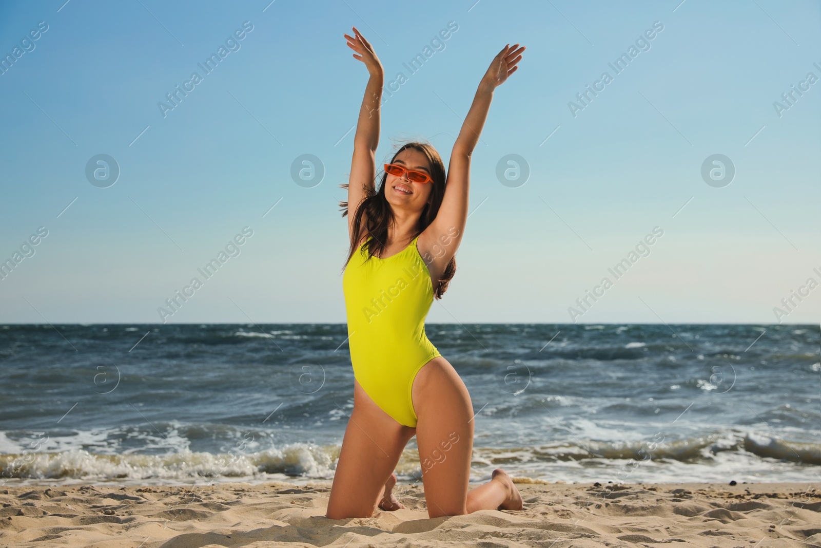 Photo of Beautiful young woman with attractive body posing on beach