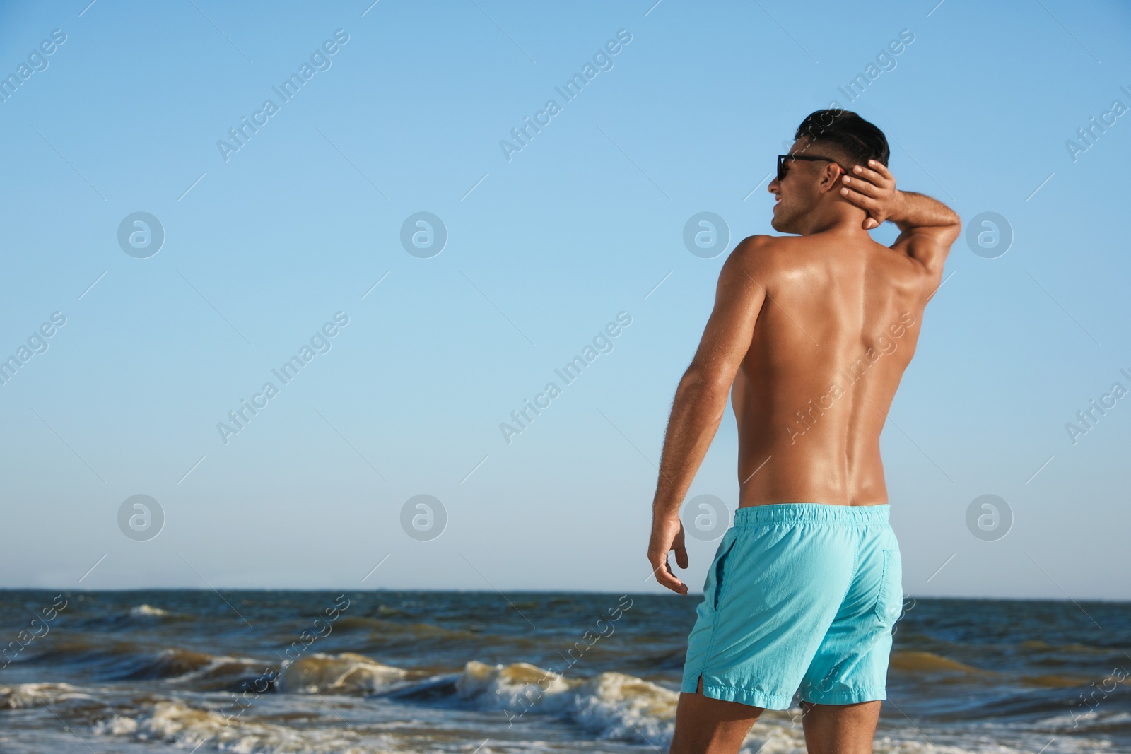 Photo of Man with attractive body on beach. Space for text