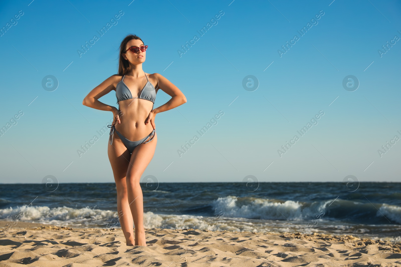 Photo of Beautiful young woman with attractive body on beach. Space for text