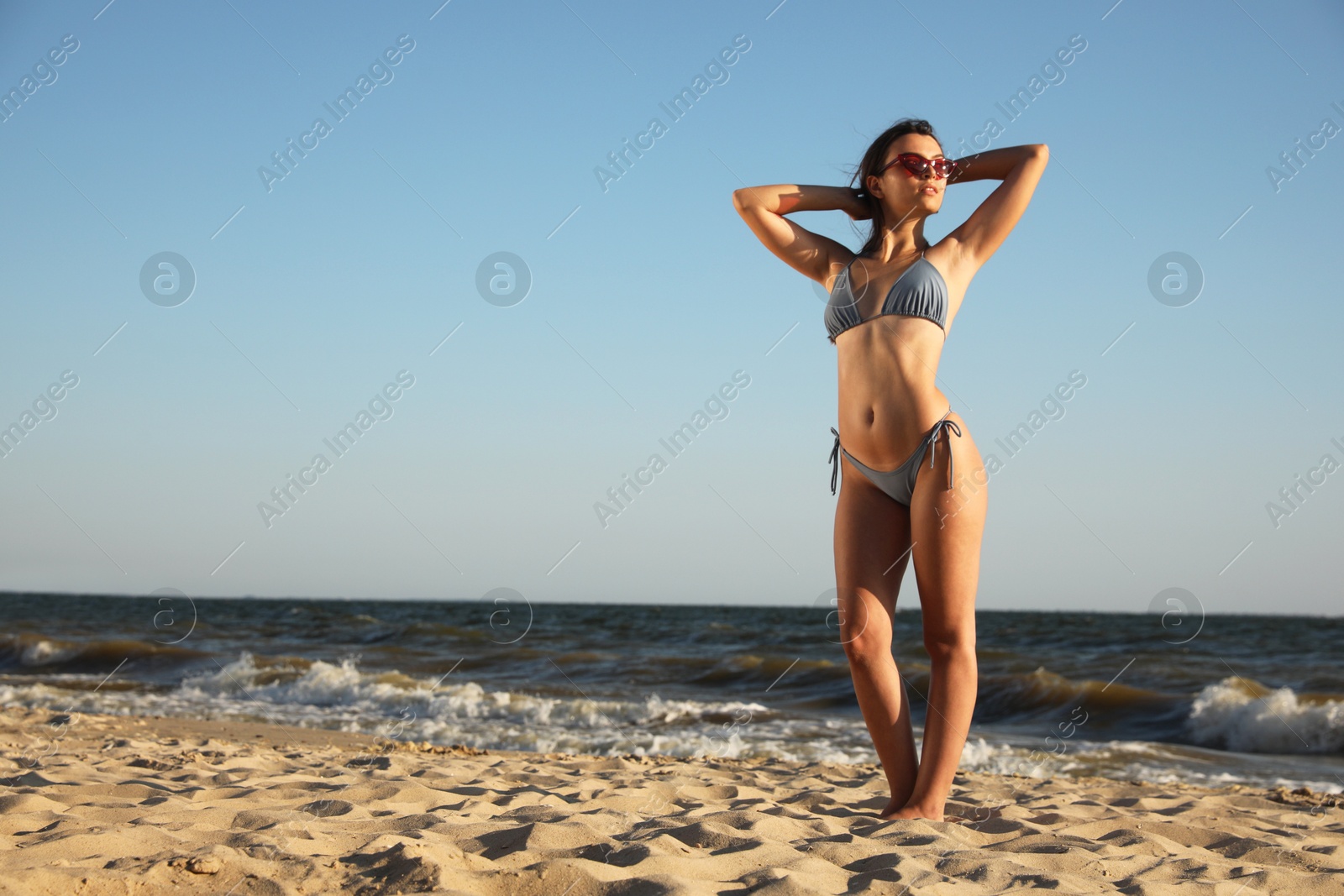 Photo of Beautiful young woman with attractive body on beach. Space for text