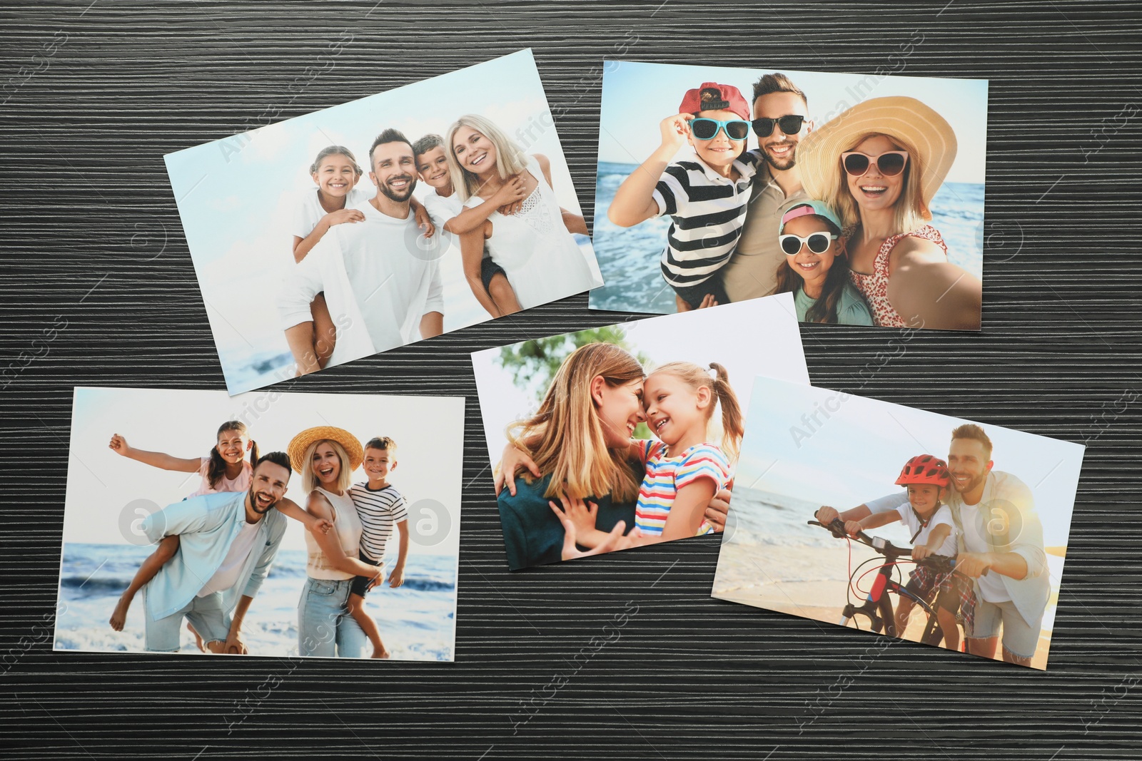 Photo of Different family photos on black wooden table, flat lay