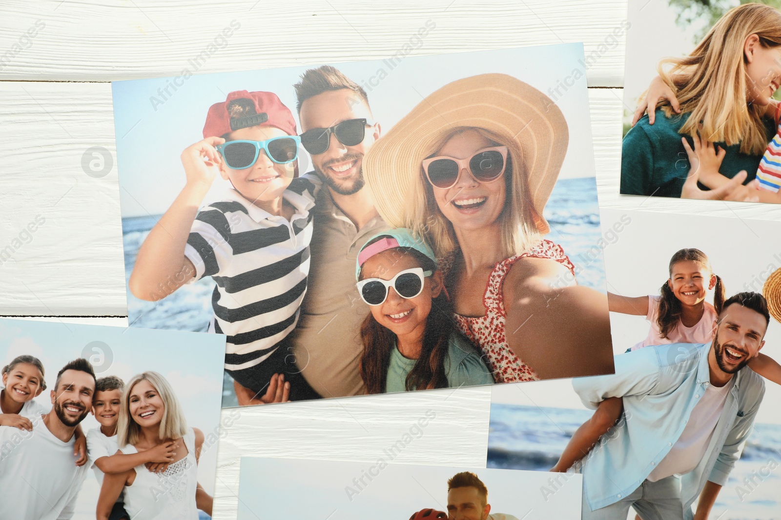 Photo of Different family photos on white wooden table, flat lay