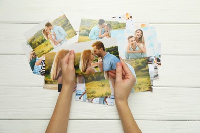 Photo of Woman with different photos at white wooden table, top view