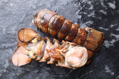 Photo of Raw lobster tails on dark table, flat lay