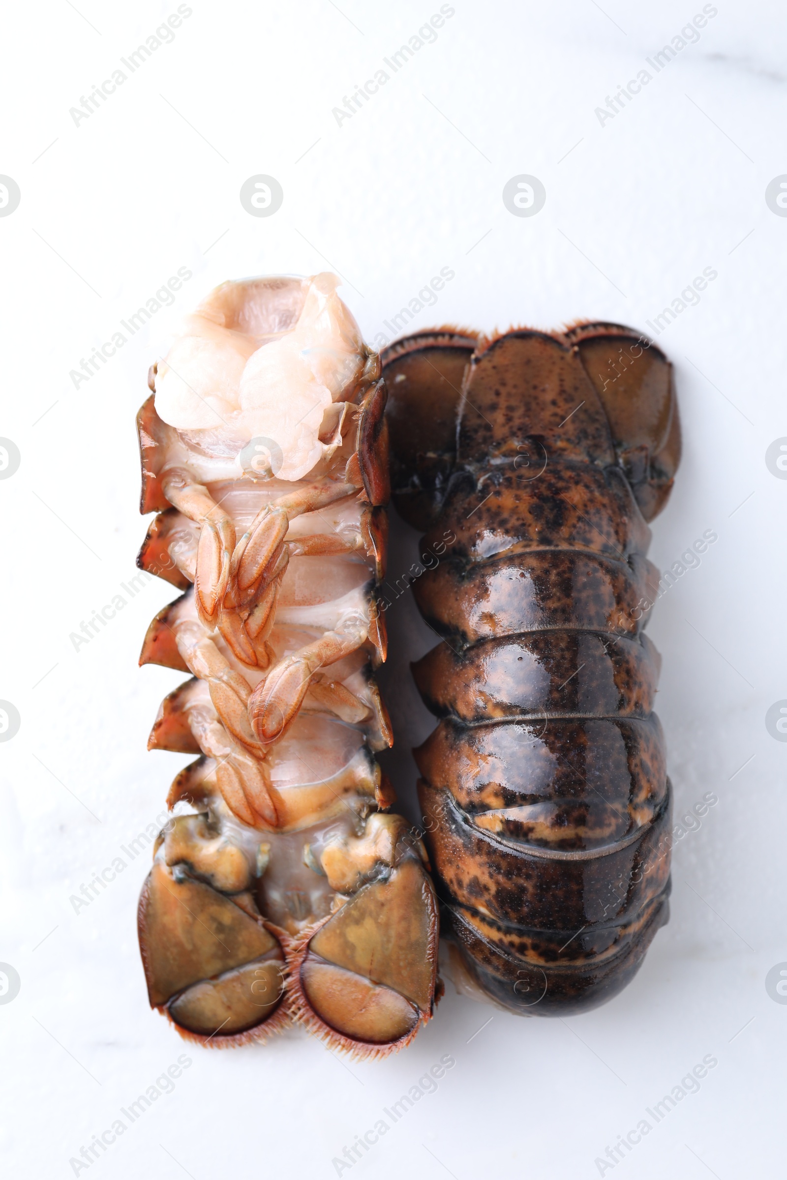 Photo of Raw lobster tails on white table, flat lay