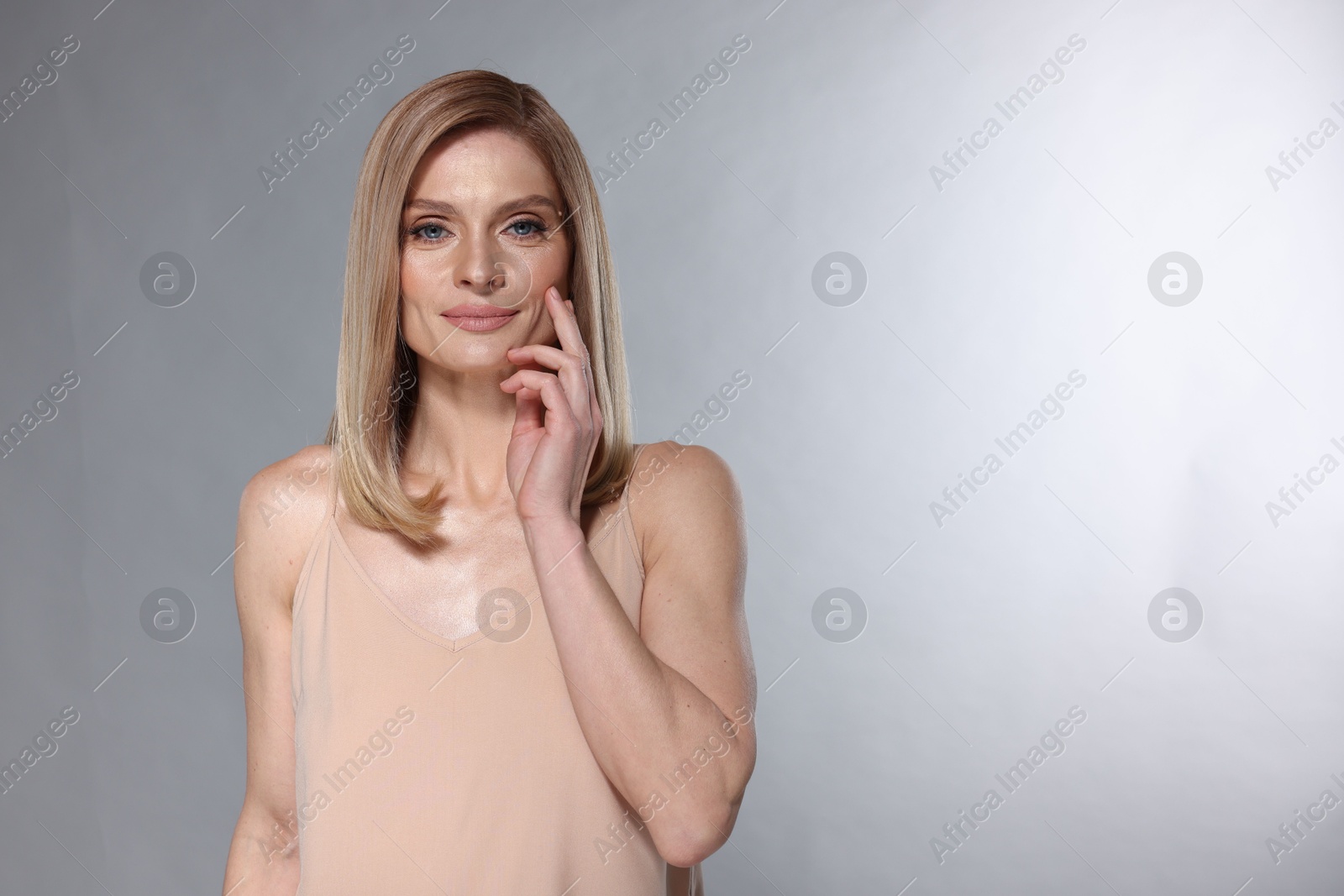 Photo of Beautiful woman with straight blonde hair on light grey background, space for text