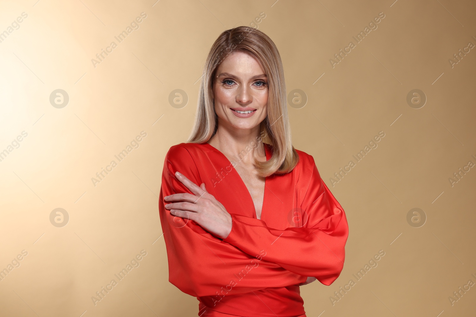 Photo of Portrait of beautiful happy woman with straight blonde hair on beige background