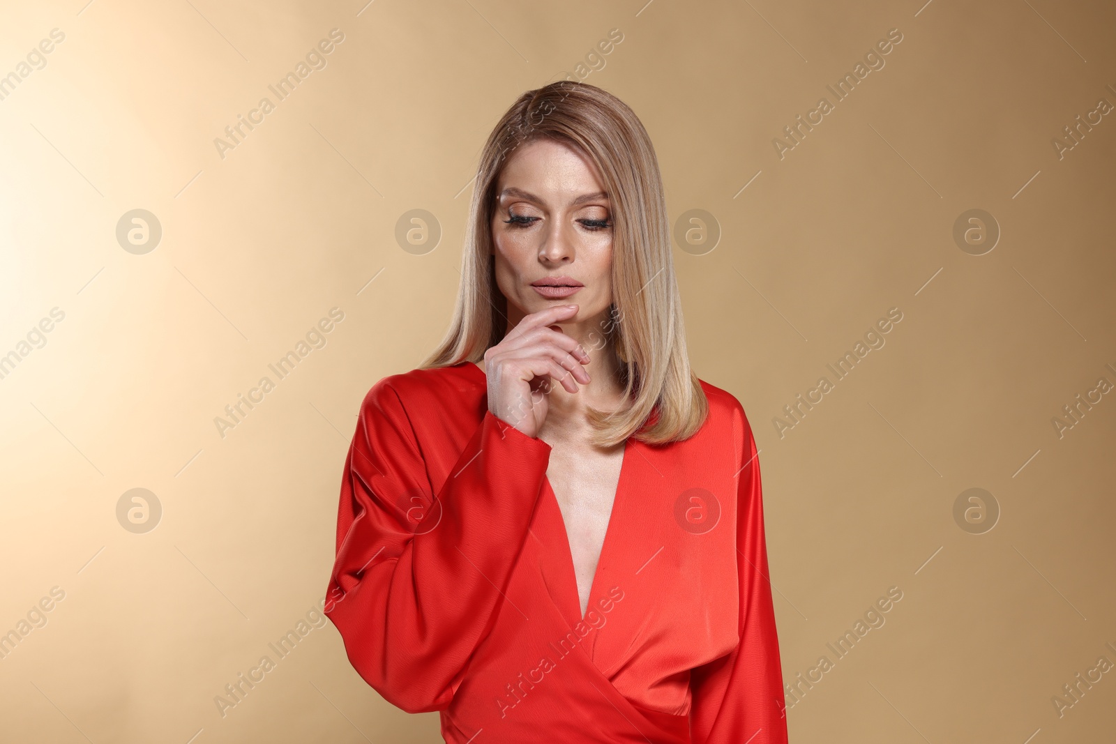 Photo of Beautiful woman with straight blonde hair on beige background