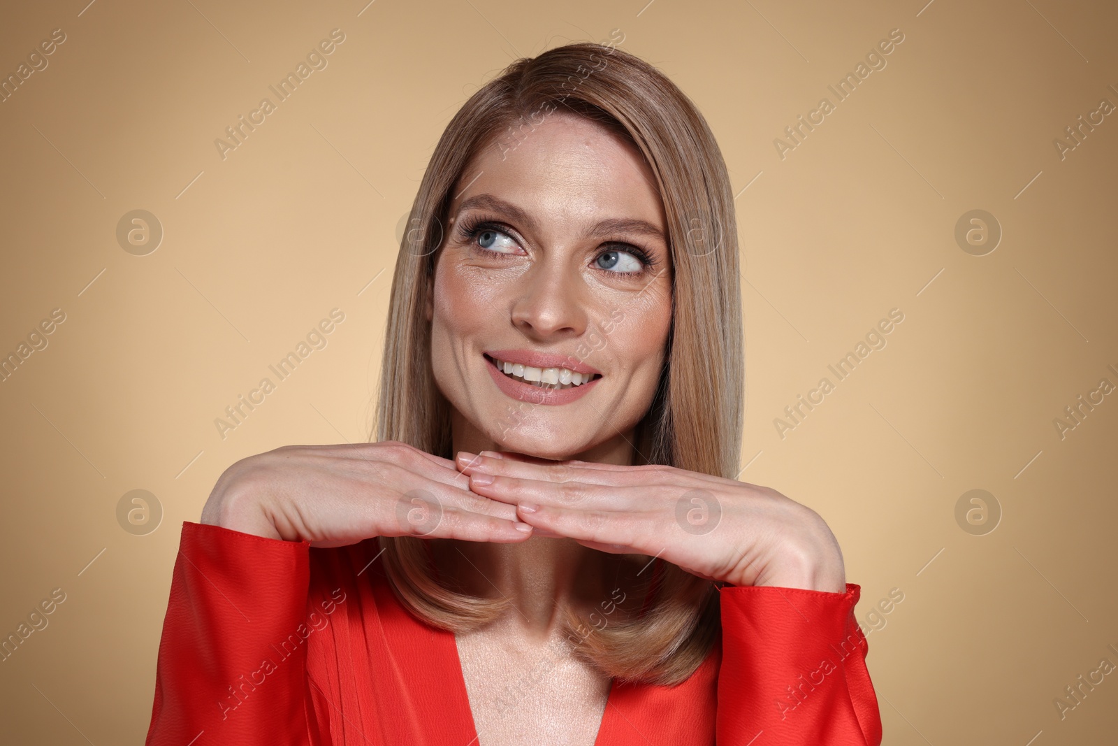 Photo of Portrait of beautiful happy woman with straight blonde hair on beige background