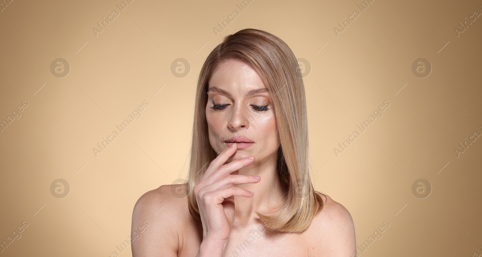 Photo of Beautiful woman with straight blonde hair on beige background