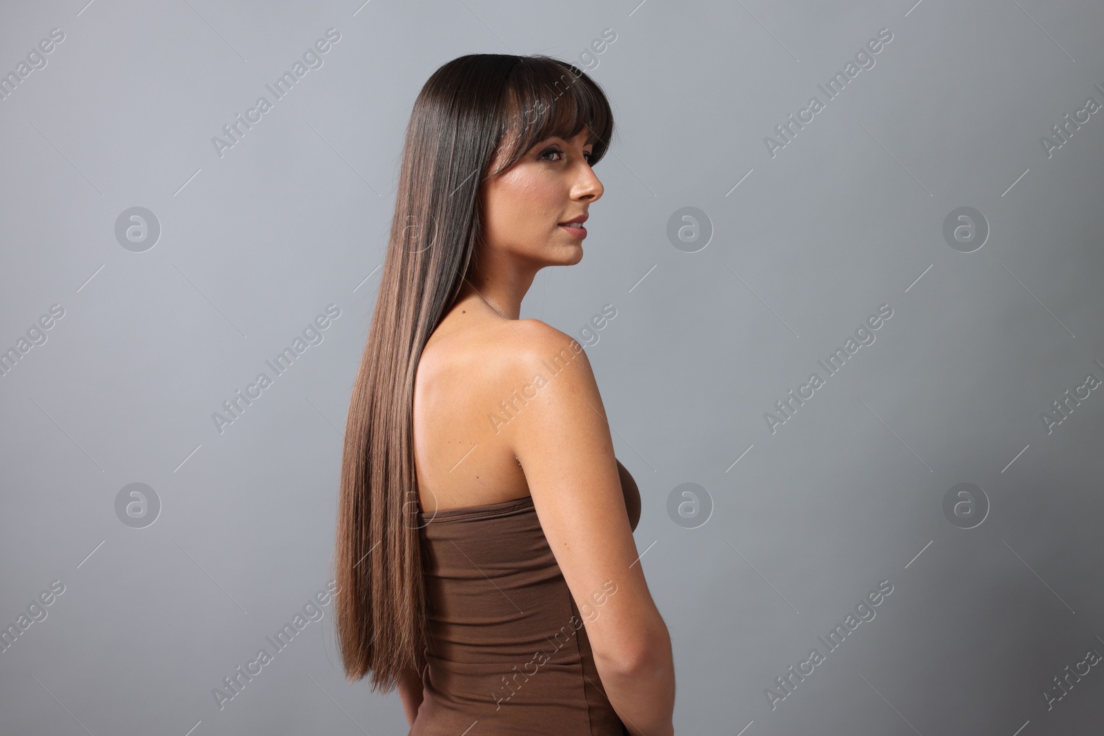 Photo of Hair styling. Beautiful woman with straight long hair on grey background, space for text