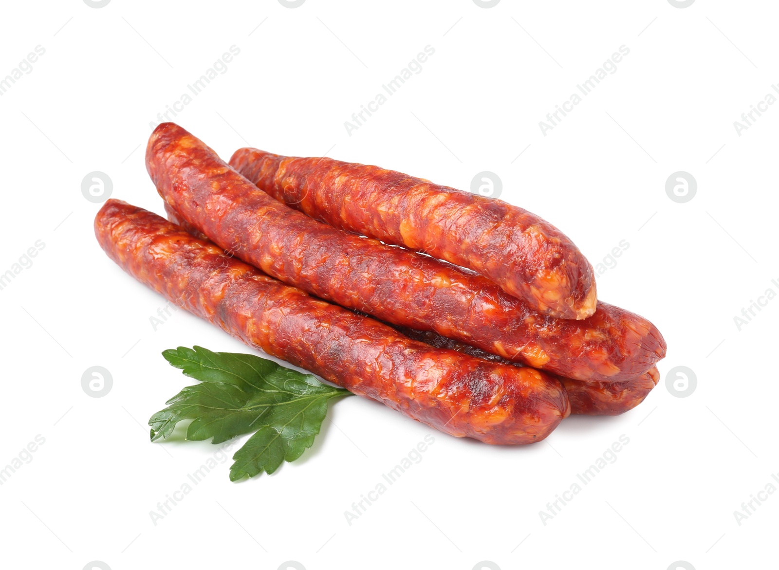 Photo of Many thin dry cured sausages with parsley isolated on white