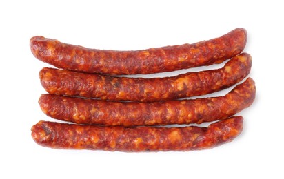 Photo of Many thin dry cured sausages isolated on white, top view