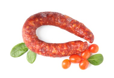 Photo of Delicious dry cured sausage with basil and tomatoes isolated on white, top view